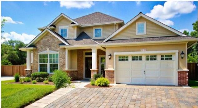 Craftsman style home exterior with stone and a paver driveway